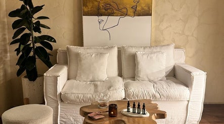 Calm lounge area at Face Therapy Spa, Umalas, Bali, ID with white sofa, art, and greenery for relaxation.