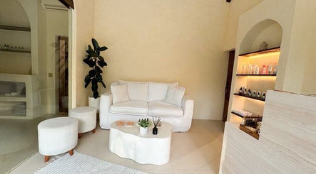 Cozy waiting area at Face Therapy Spa, Umalas with white sofa and products on display in Bali, ID.