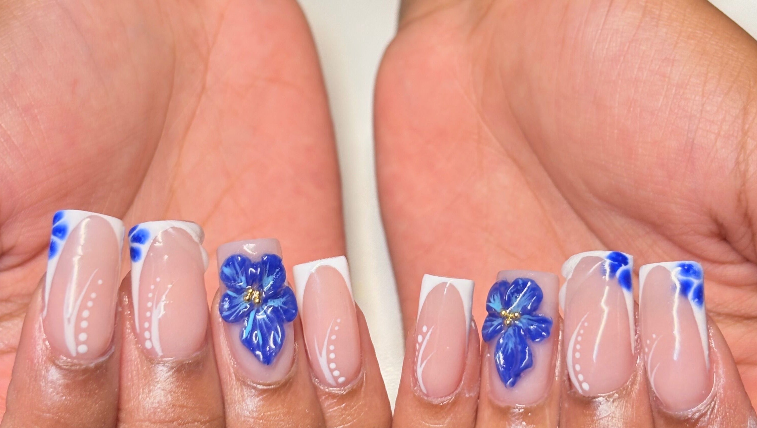 Elegant blue floral nail design at Thee Adore Beauty Bar in London, England, GB.
