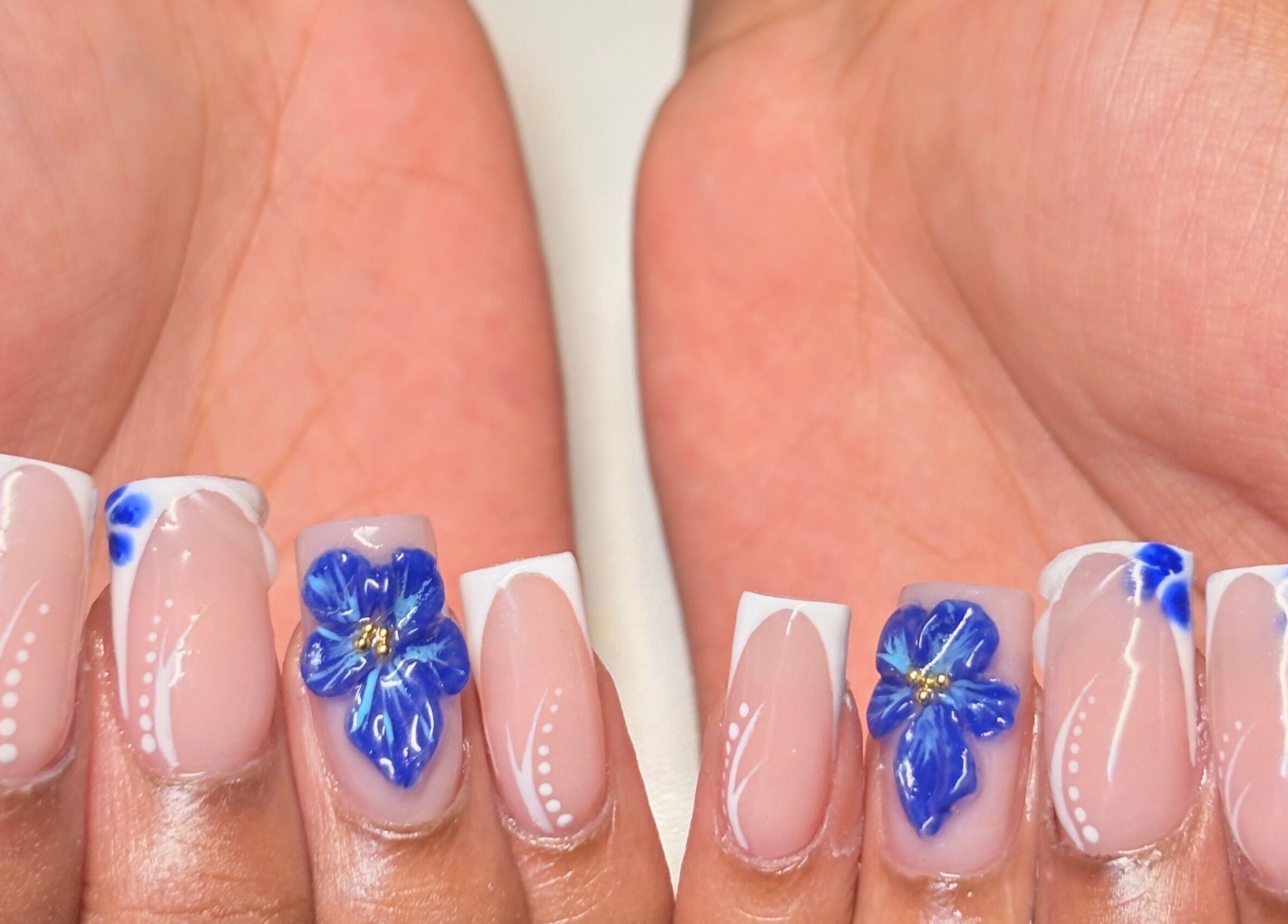 Elegant blue floral nail design at Thee Adore Beauty Bar in London, England, GB.