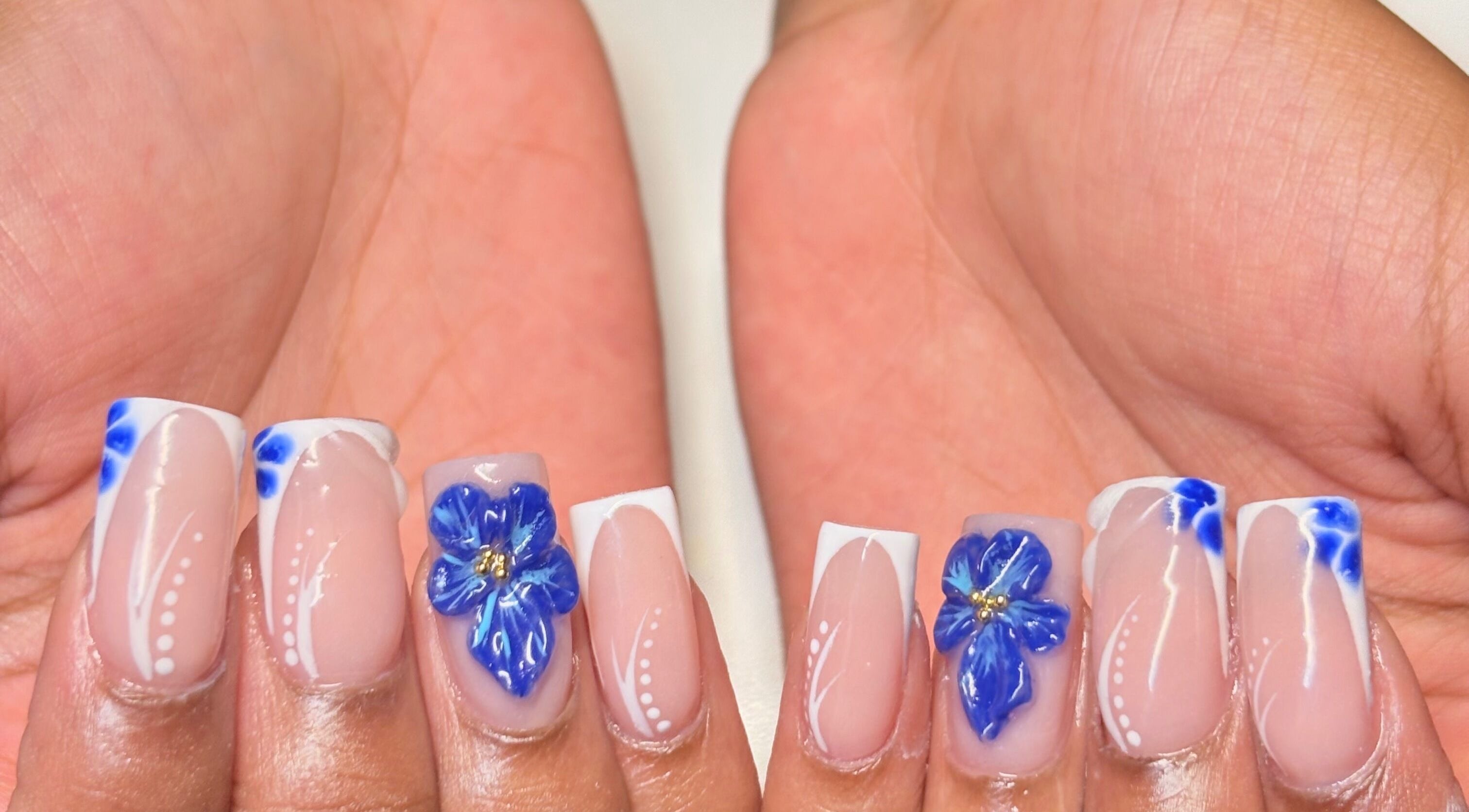 Elegant blue floral nail design at Thee Adore Beauty Bar in London, England, GB.