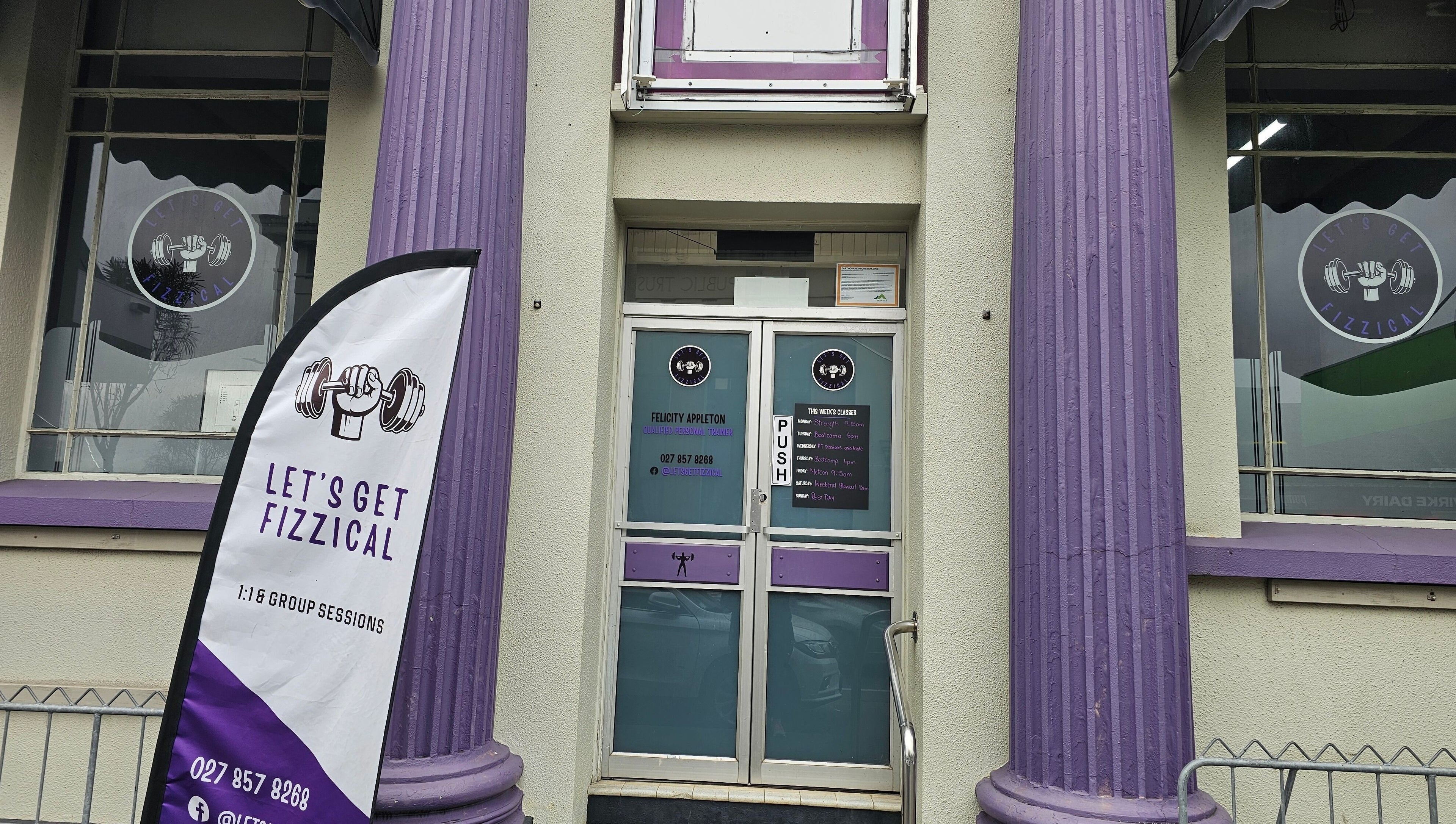 Entrance of Let's Get Fizzical in Dannevirke, Manawatū-whanganui, NZ with unique purple pillars and signage.