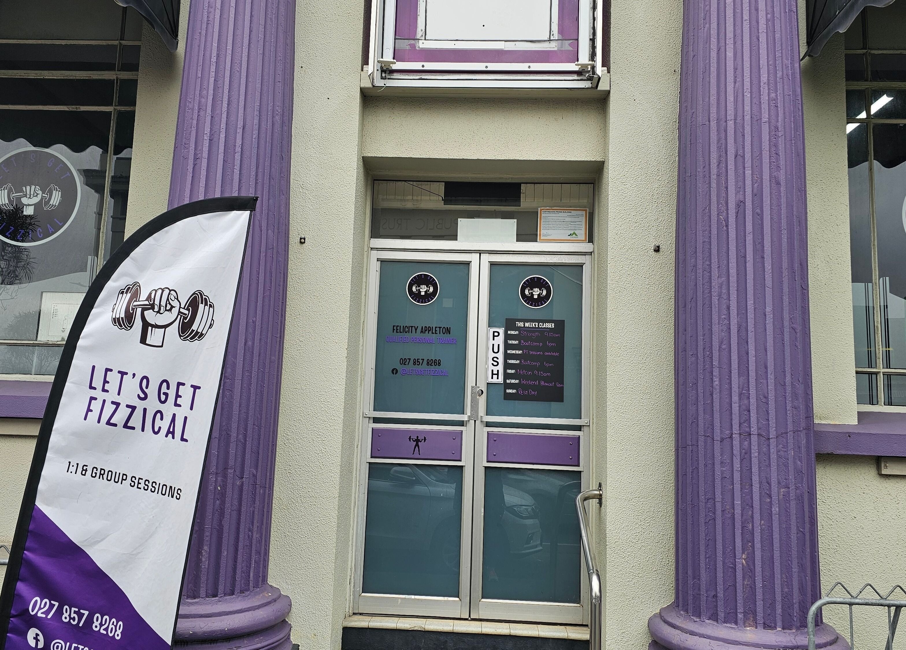 Entrance of Let's Get Fizzical in Dannevirke, Manawatū-whanganui, NZ with unique purple pillars and signage.