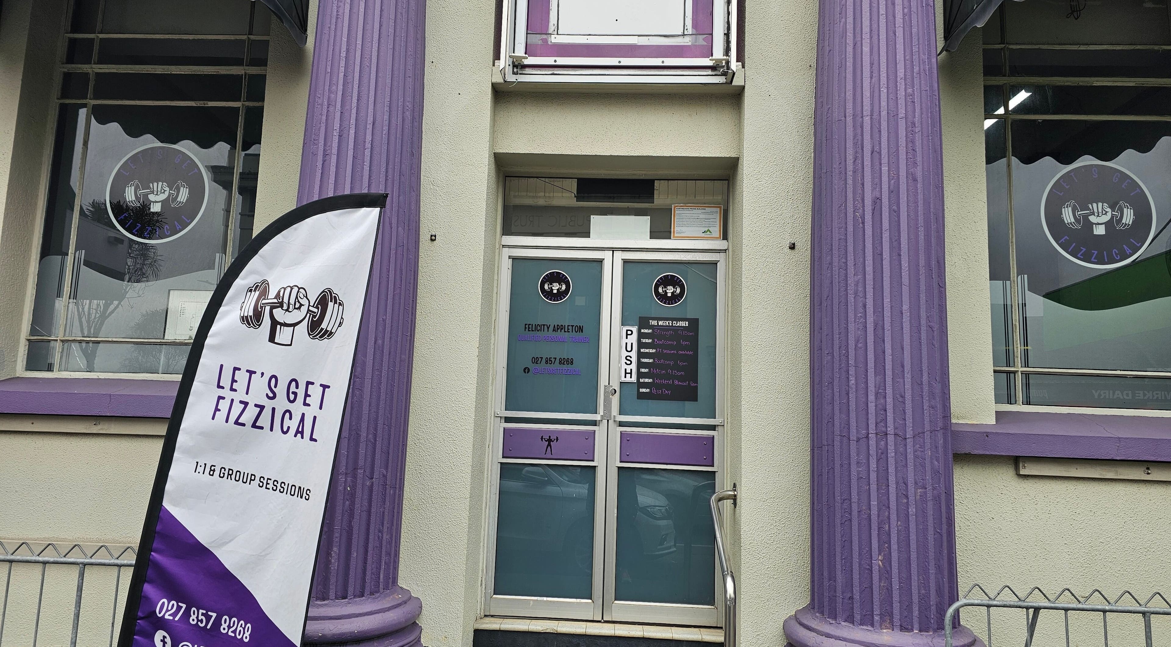 Entrance of Let's Get Fizzical in Dannevirke, Manawatū-whanganui, NZ with unique purple pillars and signage.