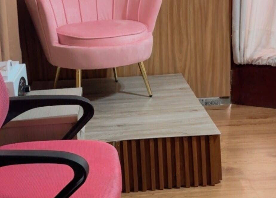 Acogedor rincón en Perla Spa Nails UY, Montevideo, con sillas rosas y elegante decoración.