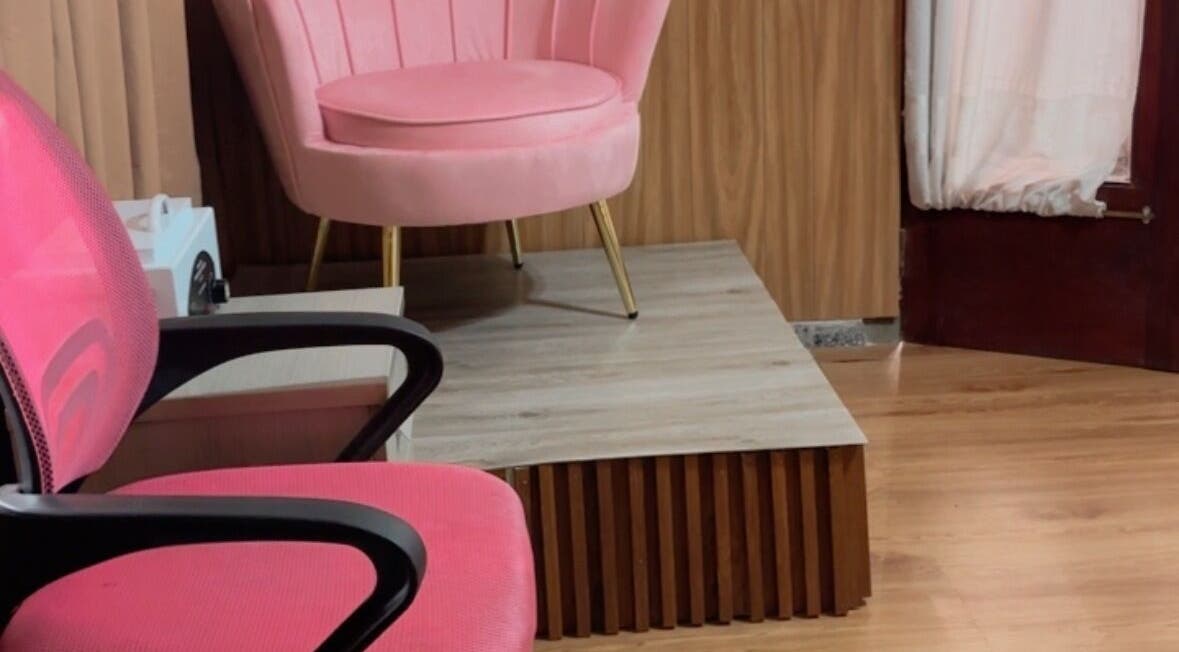 Acogedor rincón en Perla Spa Nails UY, Montevideo, con sillas rosas y elegante decoración.
