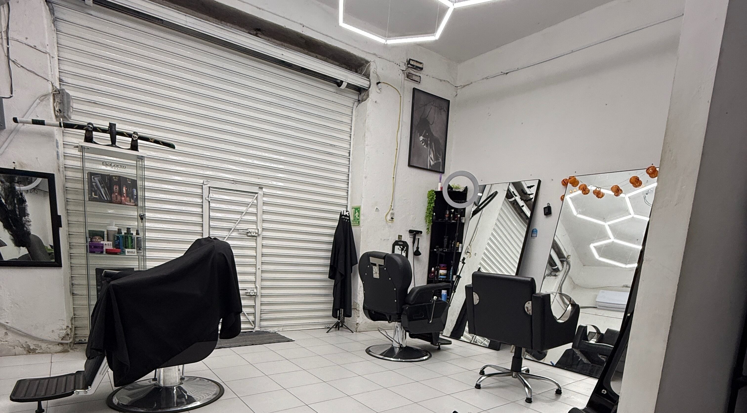 Interior moderno del 1k Barber Studio en Iguala De La Independencia, Guerrero, MX con sillas y espejos elegantes.