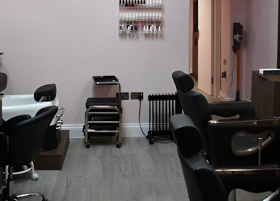 Cozy interior of Patel Sisters Aesthetic Beauty Clinic in London, England, GB with styling chairs and nail polish rack.
