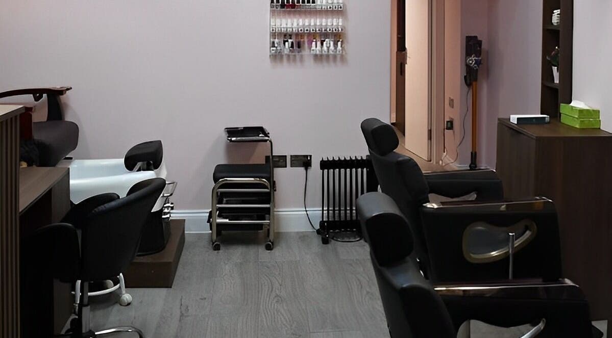 Cozy interior of Patel Sisters Aesthetic Beauty Clinic in London, England, GB with styling chairs and nail polish rack.