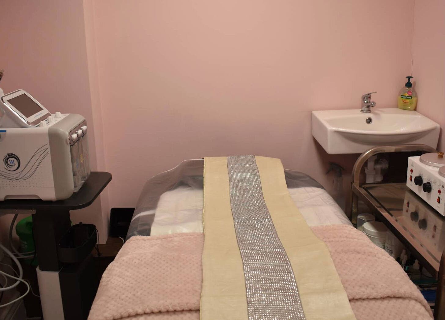 Calm treatment room at Patel Sisters Aesthetic Beauty Clinic, London, England, GB with pink walls and aesthetic equipment.