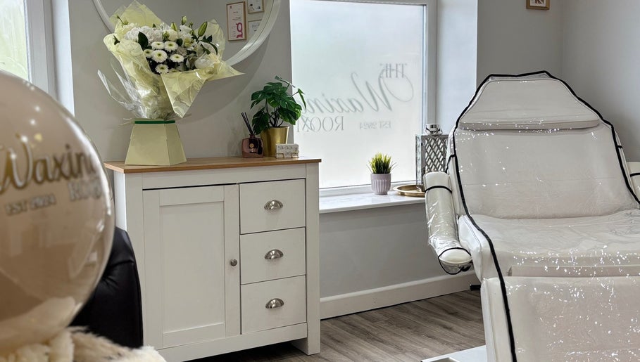 The Waxing Room in Pencoed, Wales, GB, showcasing a tranquil, relaxing setting with floral decor and plush seating.