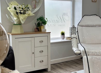 The Waxing Room in Pencoed, Wales, GB, showcasing a tranquil, relaxing setting with floral decor and plush seating.