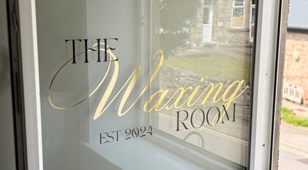 Elegant window signage of The Waxing Room in Pencoed, Wales, GB, showcasing gold lettering.