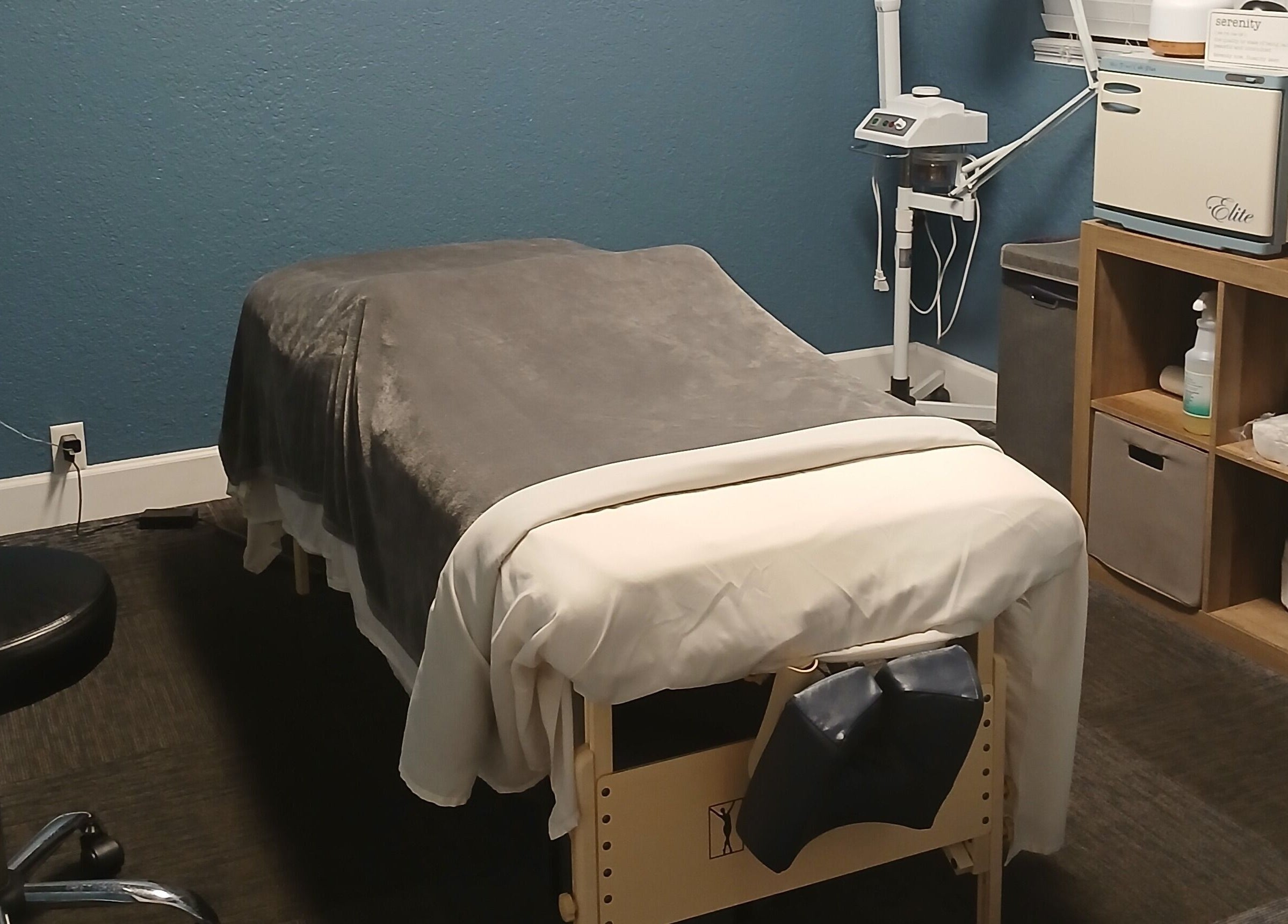 Cozy massage room at Massageology, Middleburg, Florida, US, featuring a comfortable table with a soft gray blanket.
