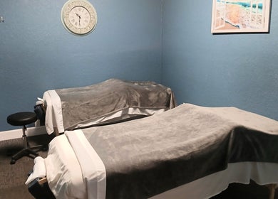 Cozy massage room at Massageology, Middleburg, Florida, US with two massage tables and calming decor.