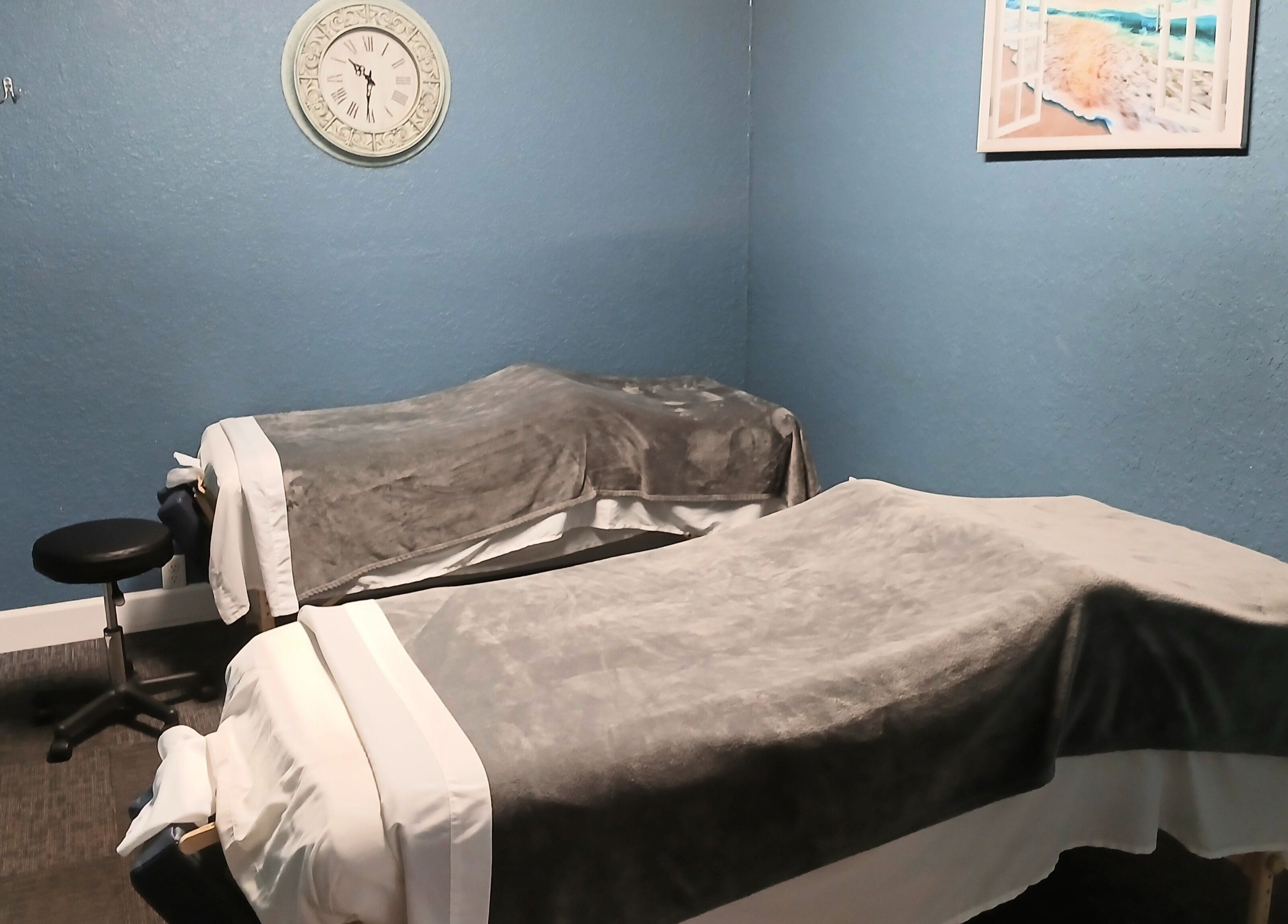 Cozy massage room at Massageology, Middleburg, Florida, US with two massage tables and calming decor.