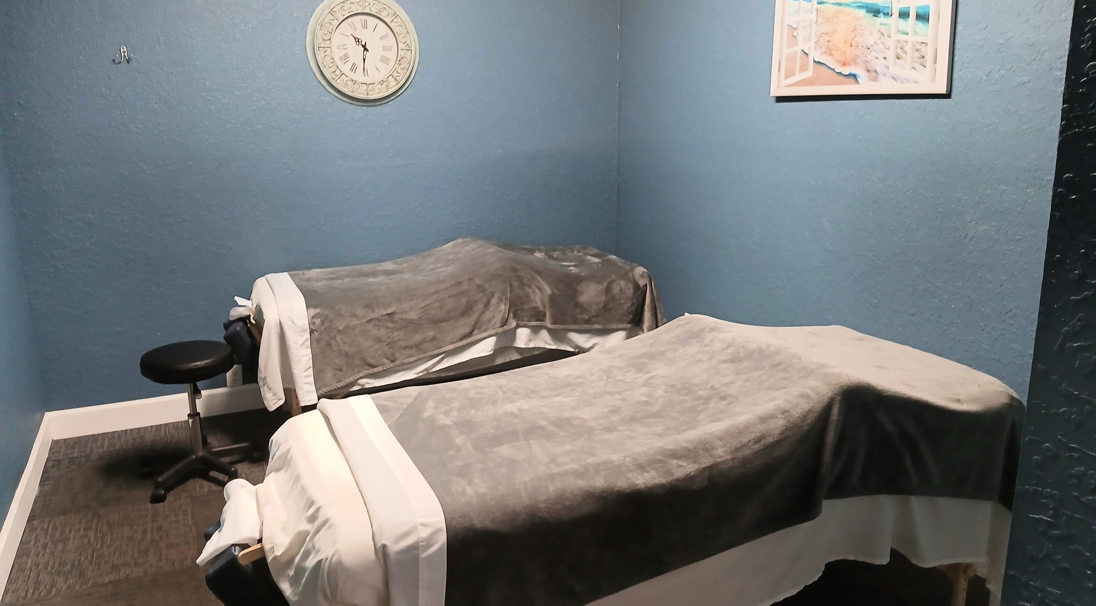 Cozy massage room at Massageology, Middleburg, Florida, US with two massage tables and calming decor.