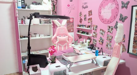 Estación de manicura en Aroa Nails, Etxebarri, Euskadi, ES con silla rosa y decoración floral.