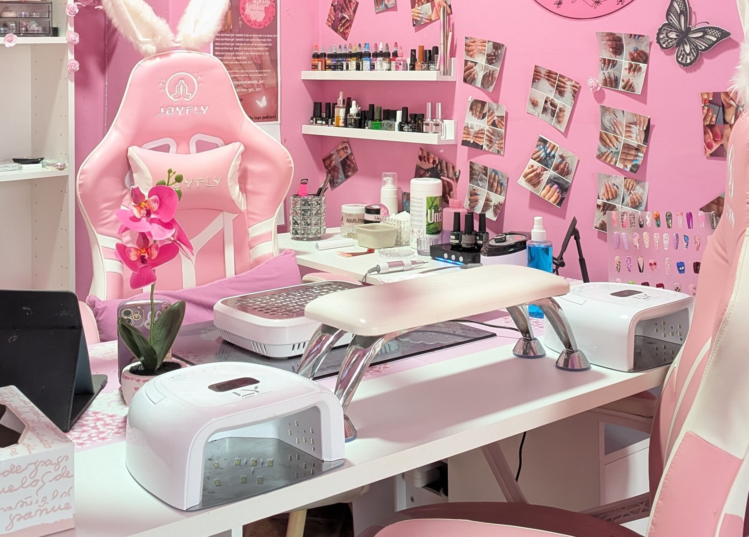 Estación de trabajo de Aroa Nails en Etxebarri, Euskadi, ES con silla rosa y decoraciones elegantes.