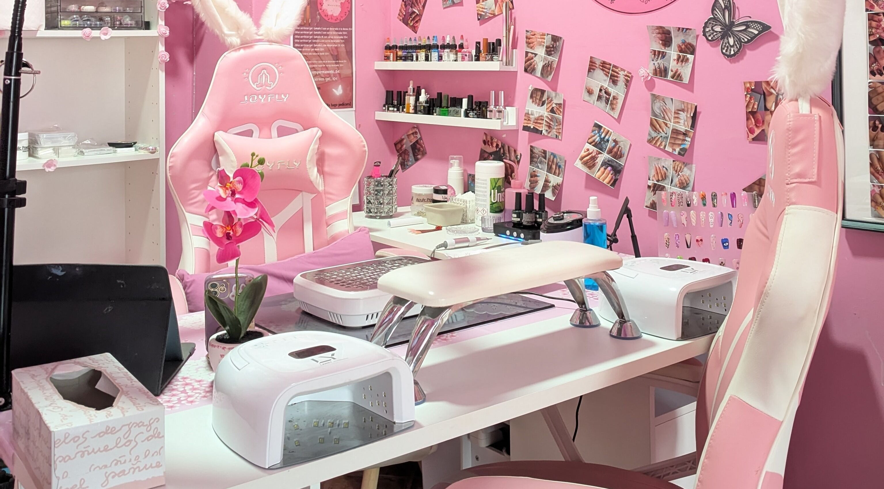 Estación de trabajo de Aroa Nails en Etxebarri, Euskadi, ES con silla rosa y decoraciones elegantes.