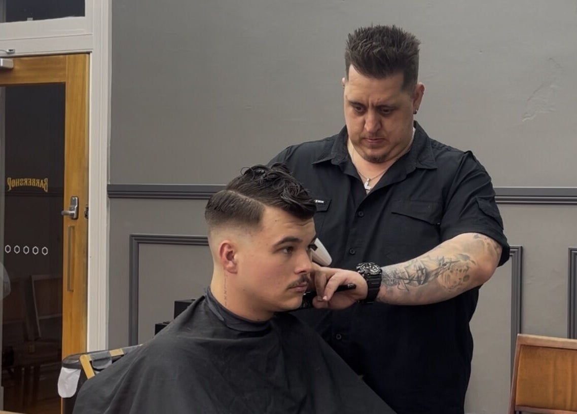 Barber styling hair at Kingdom Barbers & Co., Tamworth, New South Wales, AU.