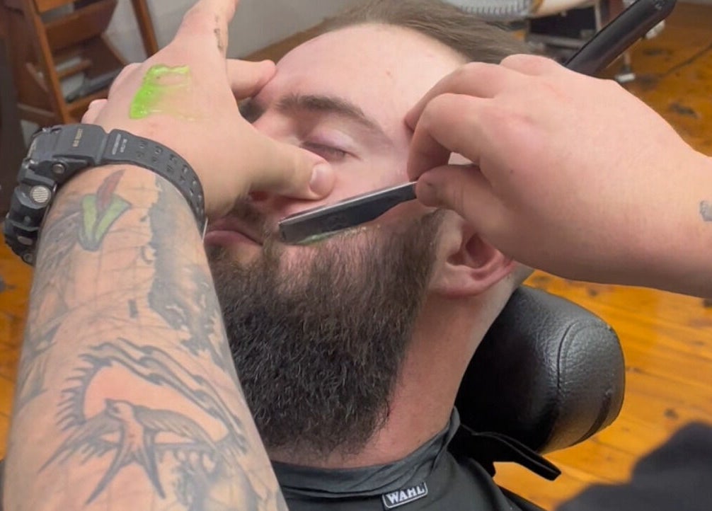 Barber performing a precise shave at Kingdom Barbers & Co., Tamworth, New South Wales, AU.