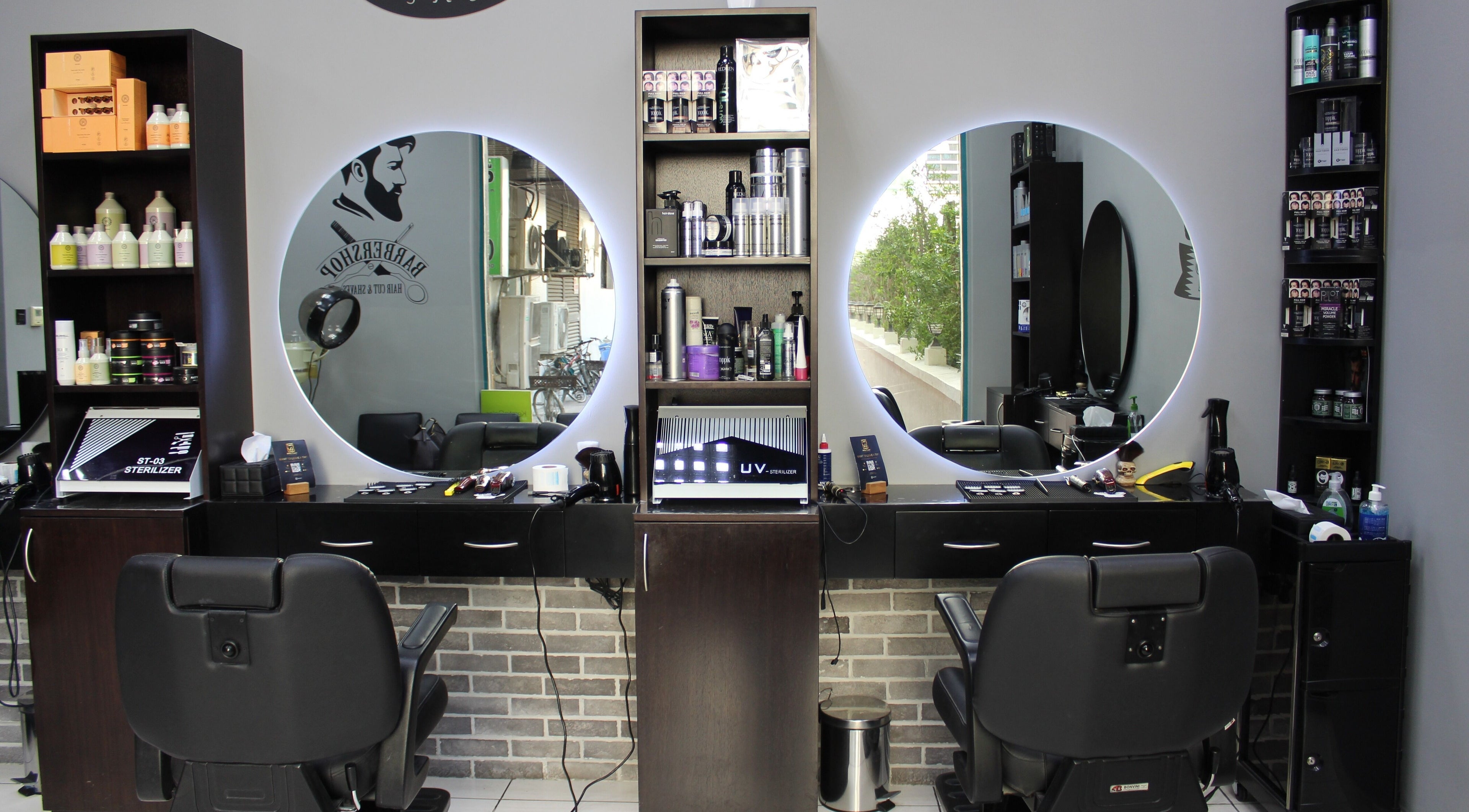 Interior of White Tower Salon صالون البرج الأبيض - Sheikh Zayed Road, Dubai, AE showcasing barber chairs and products.