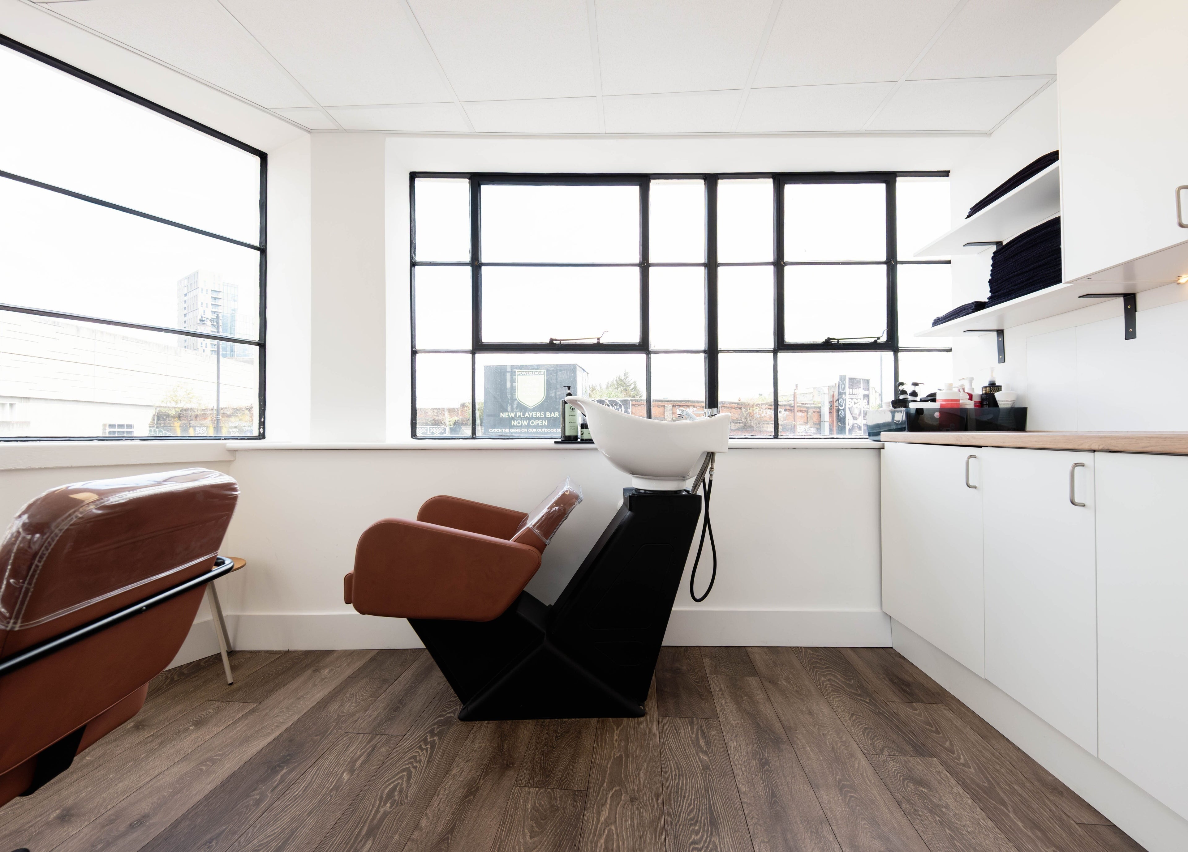 Chic salon interior at Albert Di Guida Hair London, featuring sleek chairs and natural light in London, England, GB.