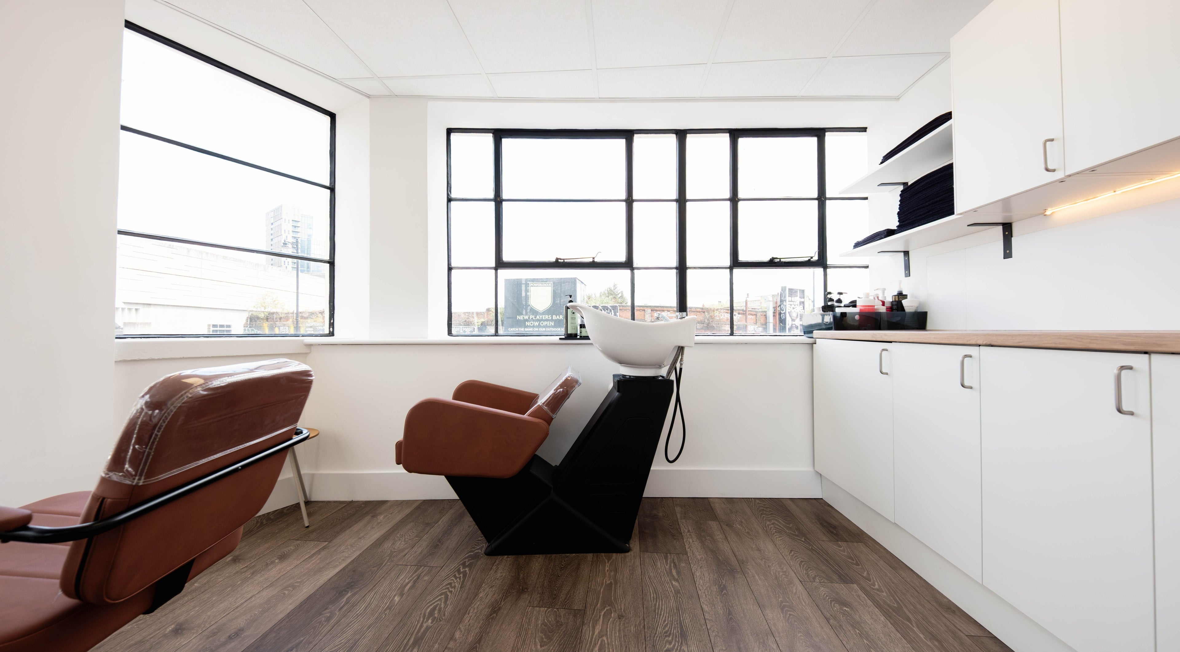 Chic salon interior at Albert Di Guida Hair London, featuring sleek chairs and natural light in London, England, GB.