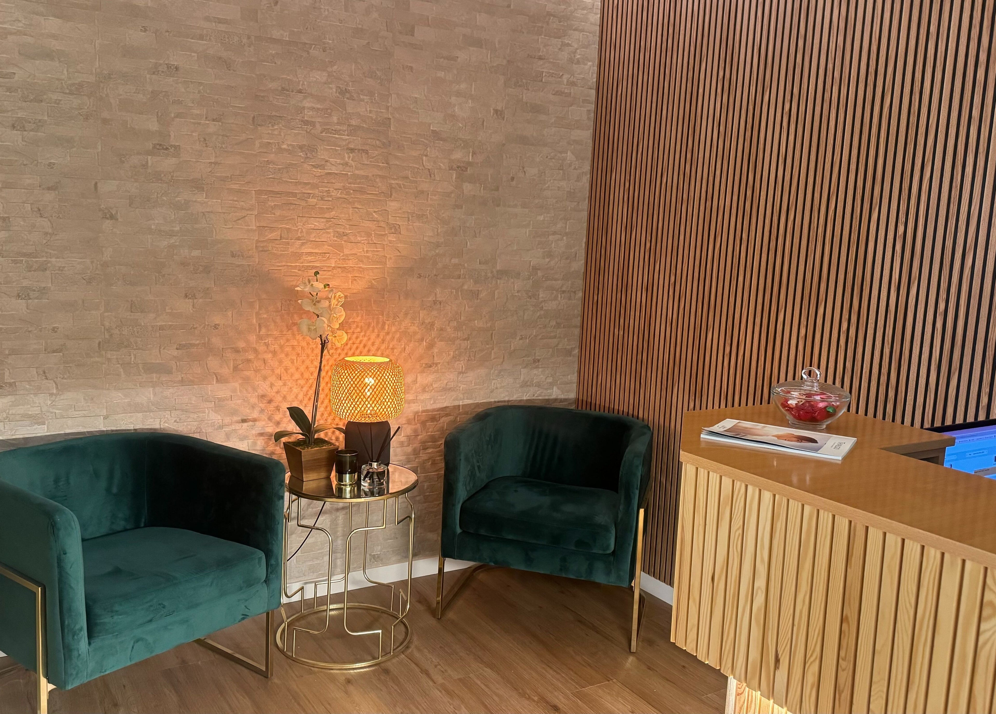 Sala de espera aconchegante no The Spa Experience em Cascais, Lisboa, PT, com cadeiras e mesa elegante.