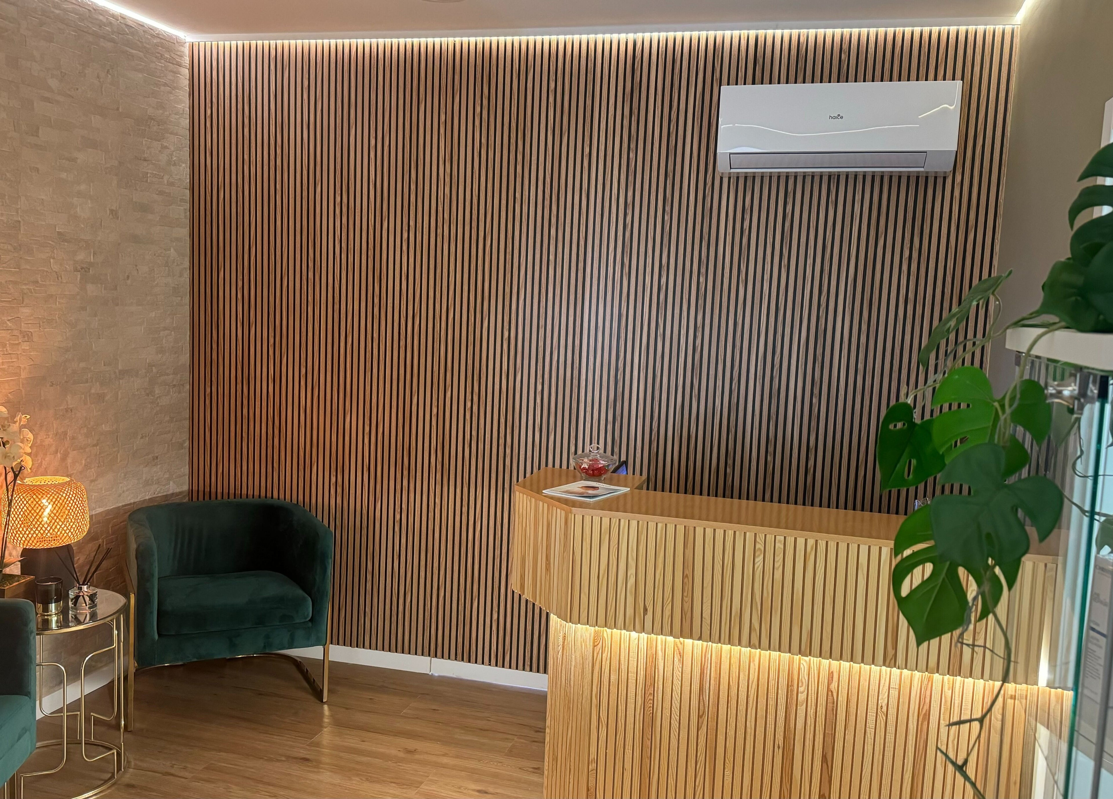 Recepção moderna em madeira de The Spa Experience, Cascais, Lisboa, PT, com poltronas verdes e luz suave.