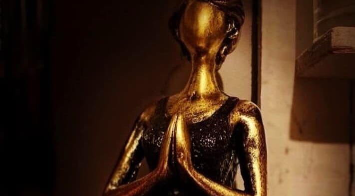 Elegant golden statue in meditative pose at KH Therapies, West Midlands, GB.