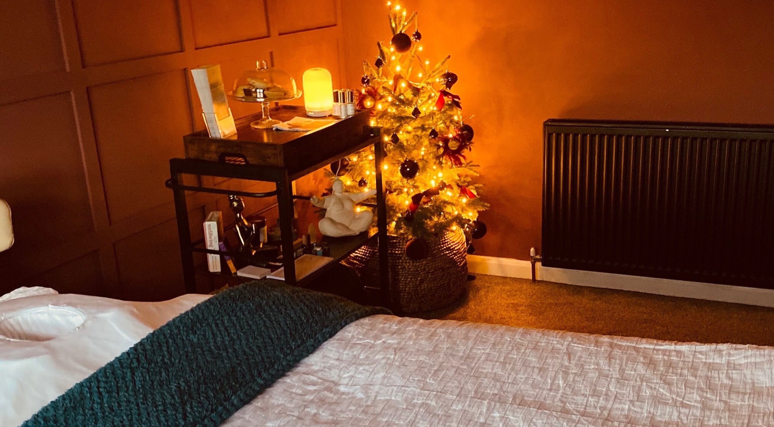 Warm, inviting therapy room at KH Therapies in West Midlands, GB, featuring a glowing festive tree.