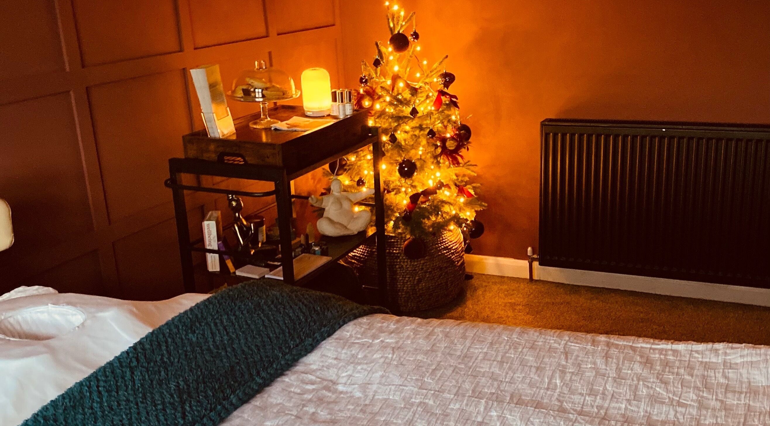 Warm, inviting therapy room at KH Therapies in West Midlands, GB, featuring a glowing festive tree.