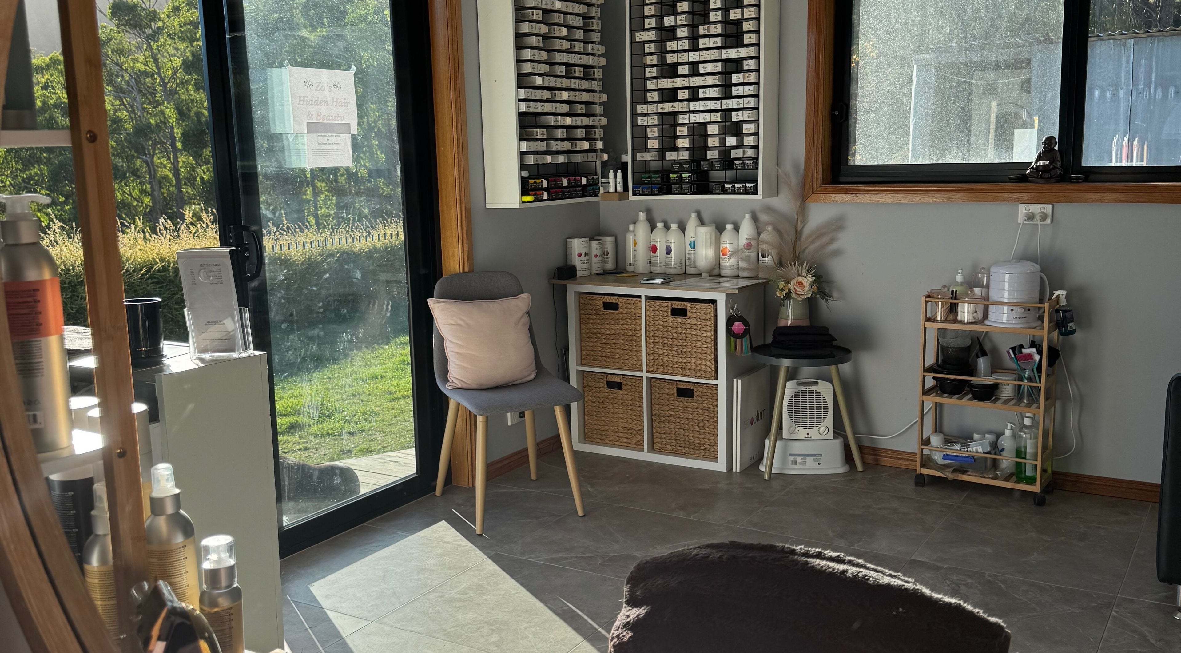 Cozy interior of Zo's Hidden Hair & Beauty in Ranelagh, Tasmania. Sunlit corner with hair products and a comfortable chair.