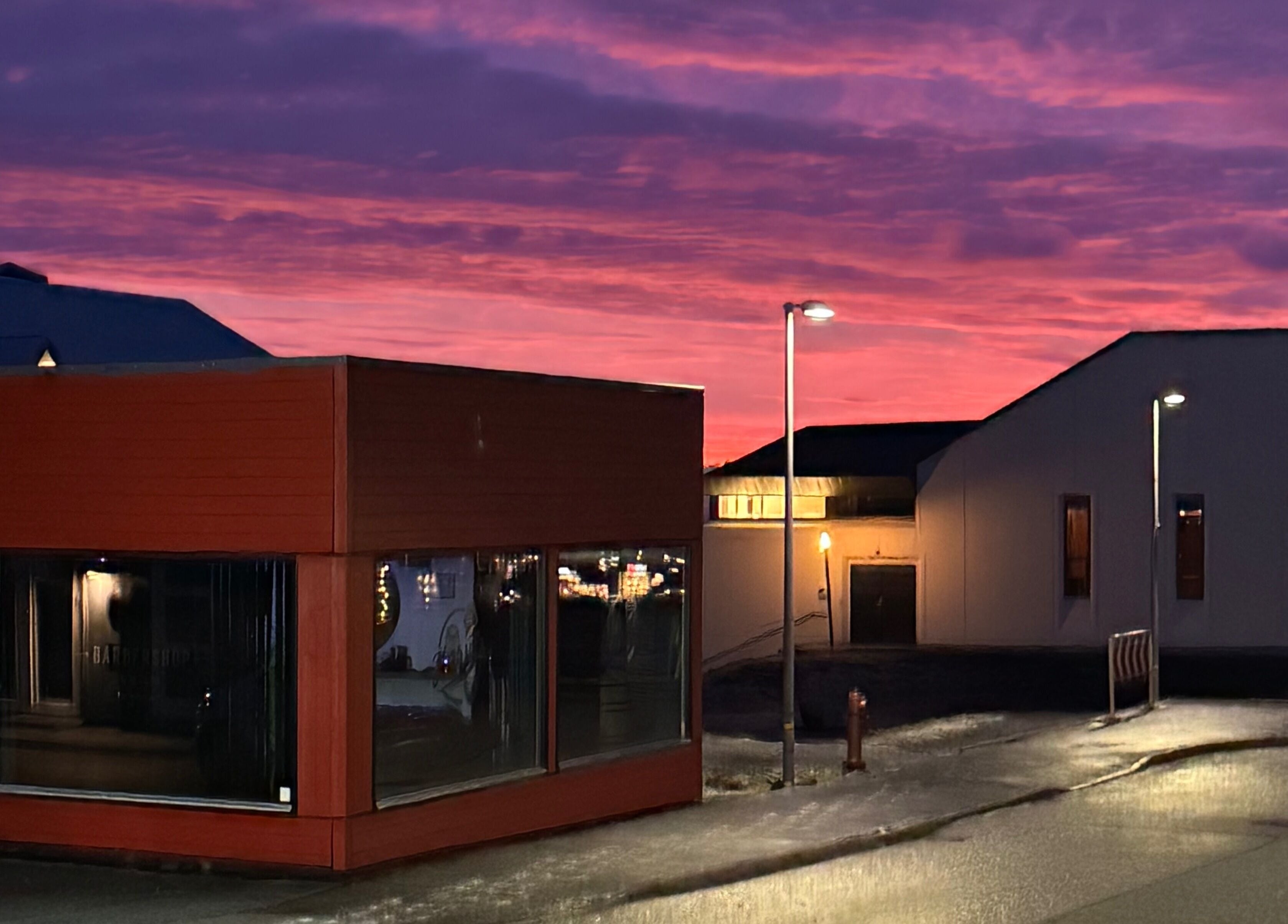 Harut’s Barbershop in Hoyvík, Streymoyar, FO, illuminated by a vibrant sunset sky.
