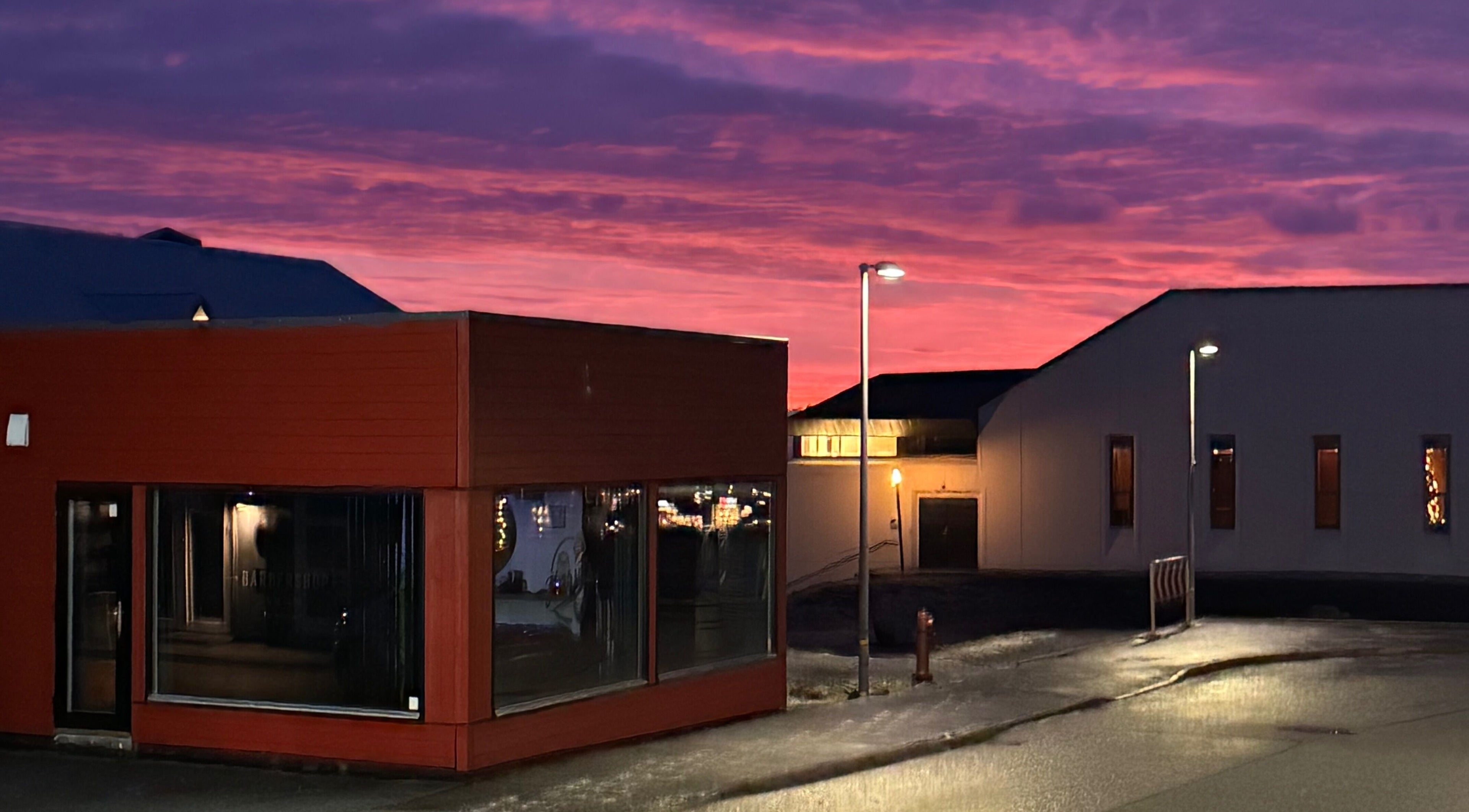Harut’s Barbershop in Hoyvík, Streymoyar, FO, illuminated by a vibrant sunset sky.