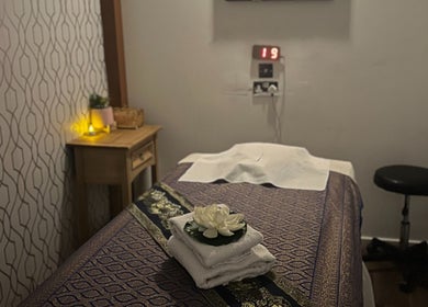 Serene massage room at Kobkun Thai Spa, featuring a lotus and towels, London, England, GB.