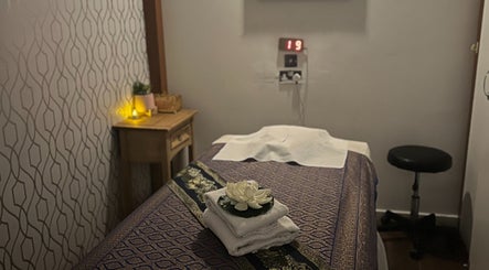 Serene massage room at Kobkun Thai Spa, featuring a lotus and towels, London, England, GB.