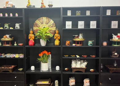 Decorative shelves at Kobkun Thai Spa, London, England, GB, showcasing Thai statues and wellness items.