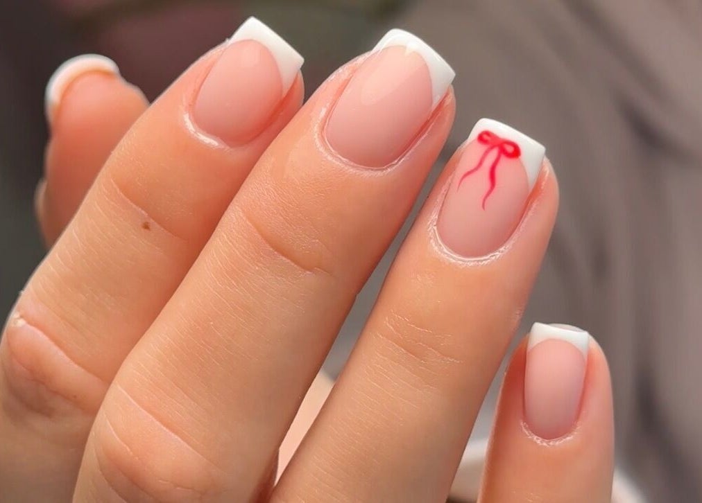 Elegant French manicure with red bow design at Gloss by PTB, Totton, England, GB.