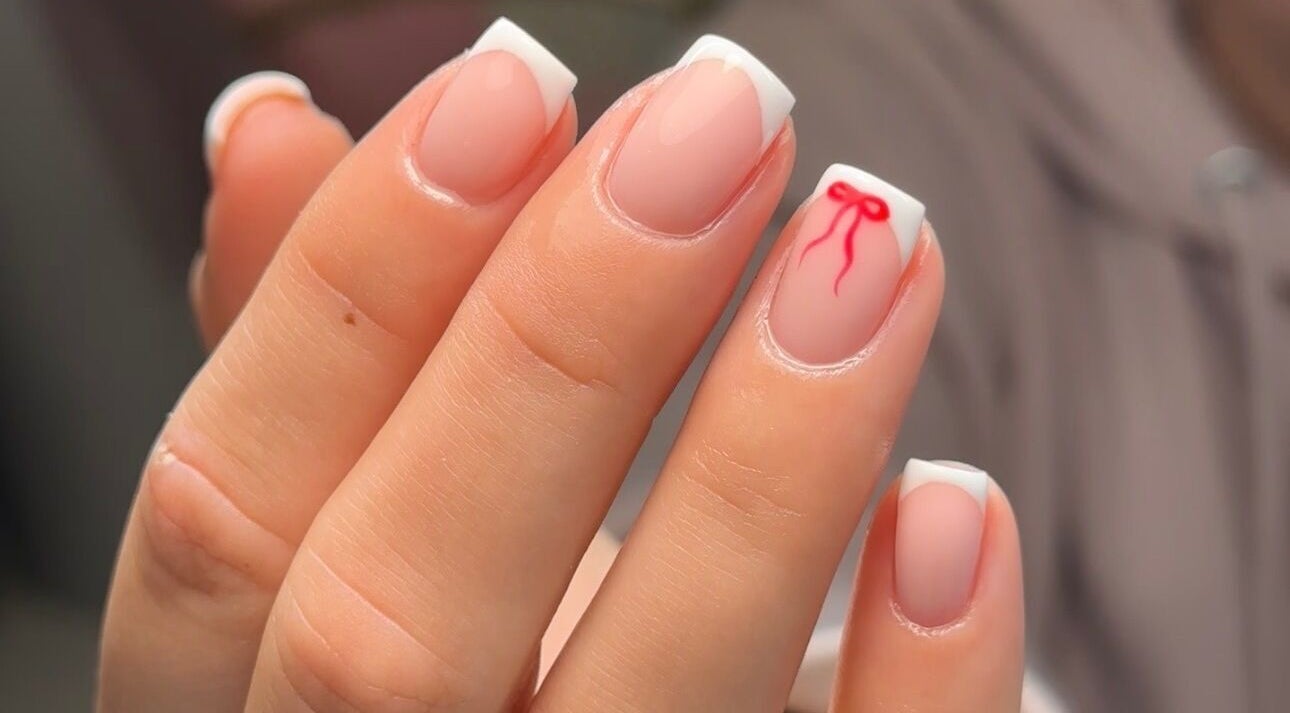 Elegant French manicure with red bow design at Gloss by PTB, Totton, England, GB.