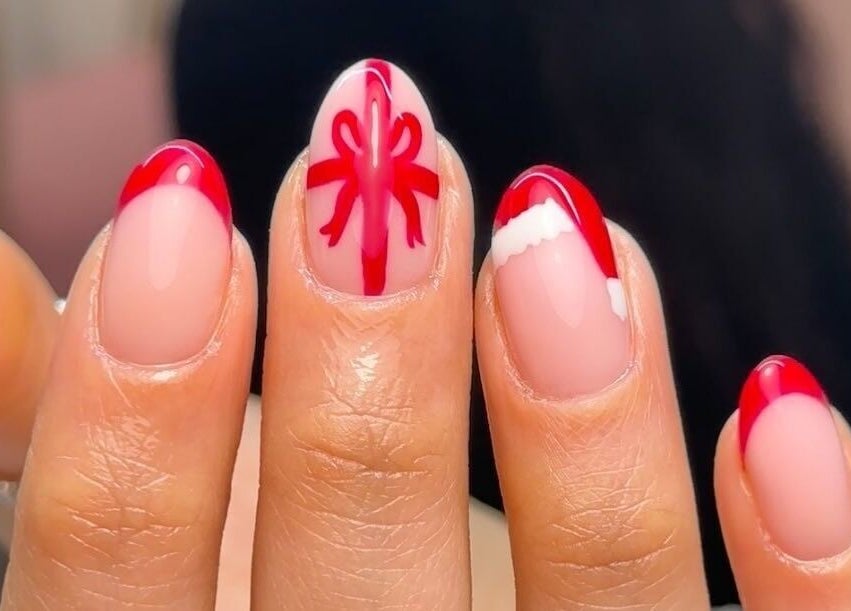Close-up of festive red and white nail art from Gloss by PTB in Totton, England, GB, showcasing elegant manicure.