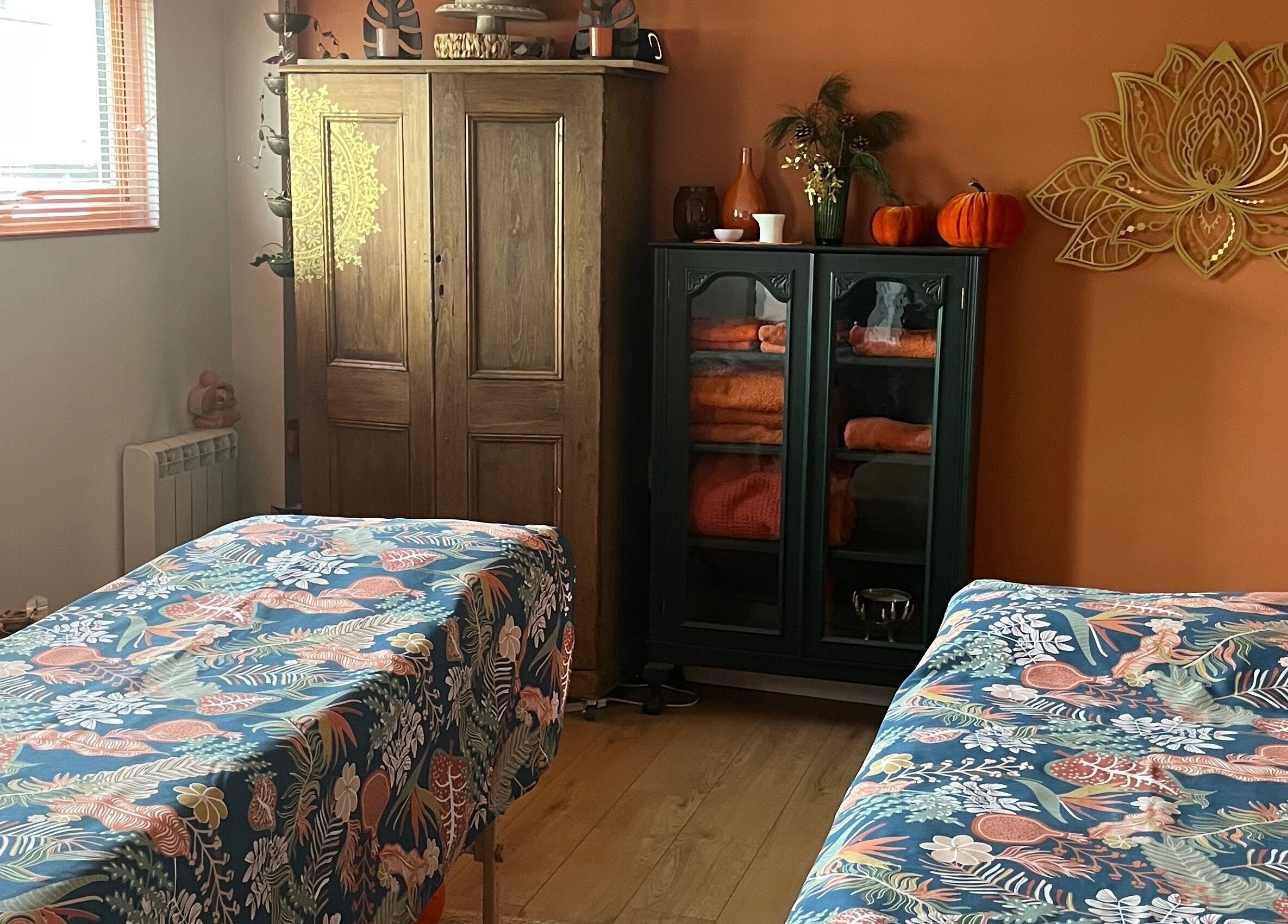 Relaxing massage room at Jinja in Devizes, England, GB with cozy decor and vibrant bed linens.