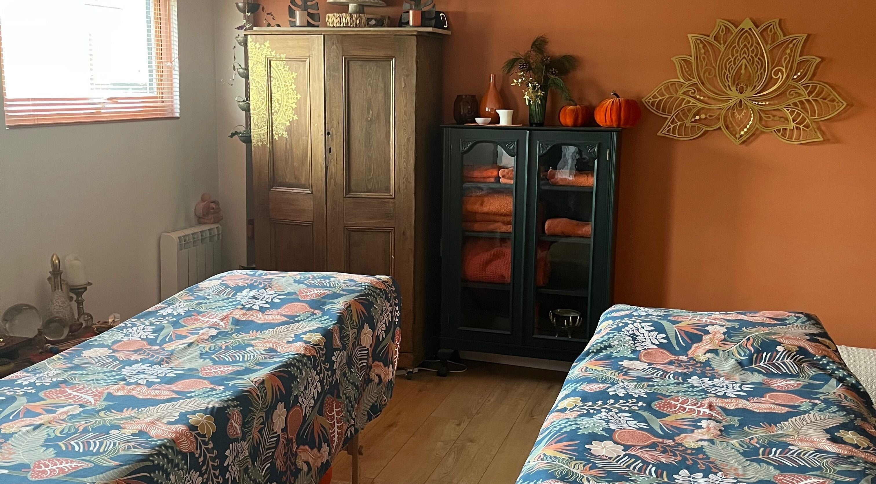 Relaxing massage room at Jinja in Devizes, England, GB with cozy decor and vibrant bed linens.