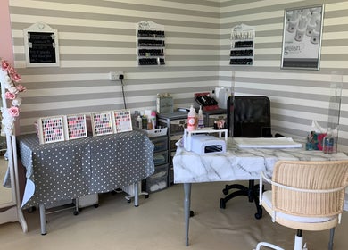 Elegant nail care station at Care Love Pamper Limited, Frodsham, England, GB, featuring a marble table and polish displays.