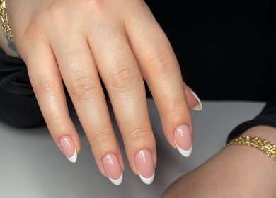 Elegant French manicure at Nail Standards, Austin, Texas, US, featuring glossy pink nails with white tips.