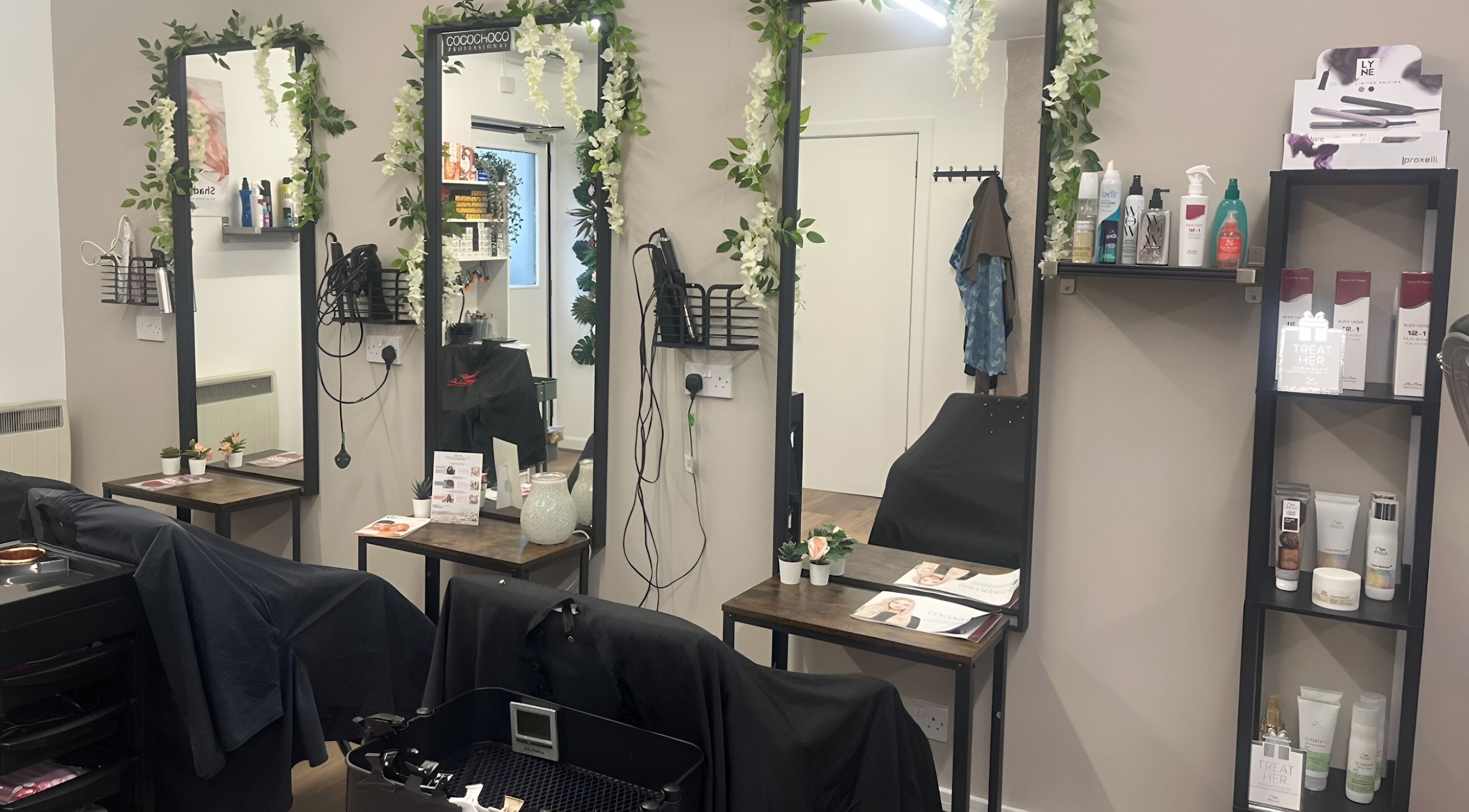 Stylish salon interior of Murphy’s Hair & Fade's, East Calder, Scotland, GB showcasing chic mirrors and product shelves.