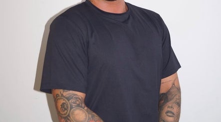 Dean Aesthetics expert with tattooed arm in Little Lever, England, GB, showcasing artistry and style.