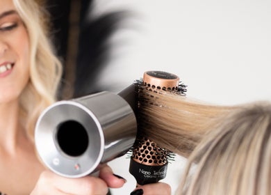 Stylist blow-dries hair at Loretta's Hair Spa in Papamoa, Bay Of Plenty, NZ, showcasing expert salon services.